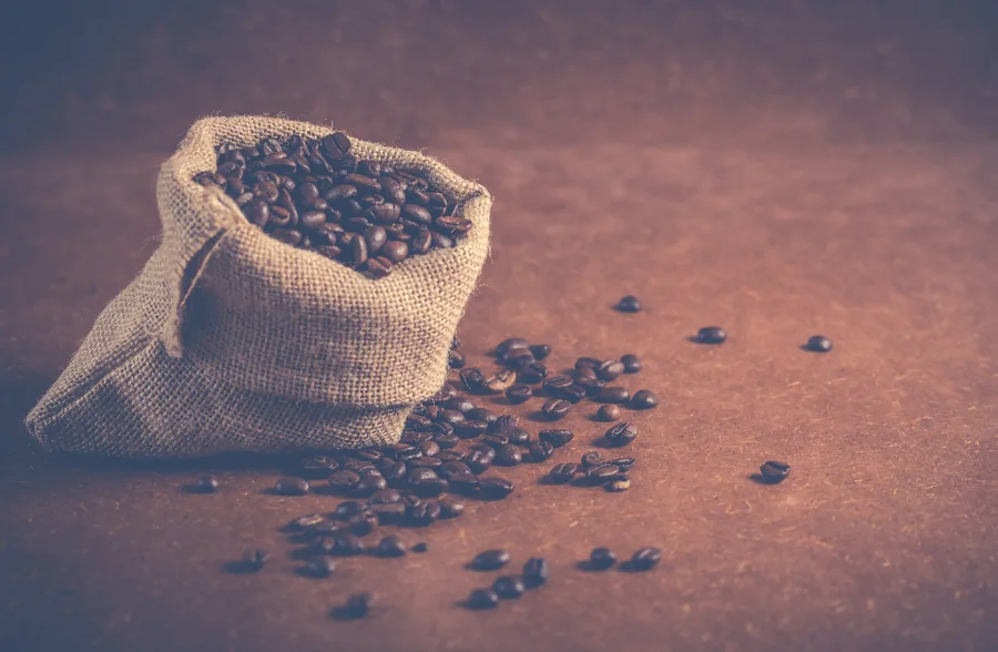 An open burlap sack of coffee beans
